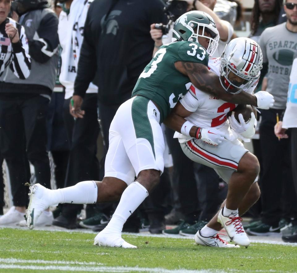 Michigan State Spartans cornerback Kendell Brooks (33)  tackles Ohio State Buckeyes wide receiver Emeka Egbuka (2) during first-half action on Saturday, Oct. 8, 2022 at Spartan Stadium.