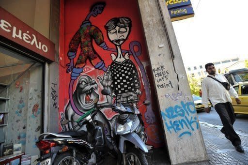 A man walks past graffiti related to the economic crisis in central Athens. The leaders of the eurozone's four biggest economies on Friday vowed measures to boost growth in the face of a relentless debt crisis, including an injection of up to 130 billion euros ($163 billion)