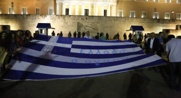 Protesters hold a large Greek flag at the anti-austerity