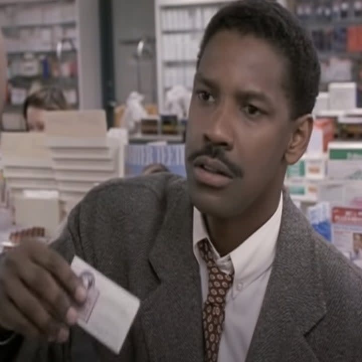 Denzel Washington holds up a card