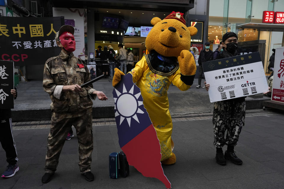 Protesters against the Chinese Communist Party dress up to depict authoritarian China and Winnie the Pooh representing Chinese President Xi Jinping, dressed as an emperor, and holding a Taiwan island cardboard cutout colored with the Taiwan flag in Taipei, Taiwan, Sunday, Jan. 7, 2024. Using military threats, diplomatic pressure, fake news and financial inducements for politicians, China is deploying a broad strategy to influence voters in Taiwan’s elections to pick candidates who favor unification. (AP Photo/Ng Han Guan)