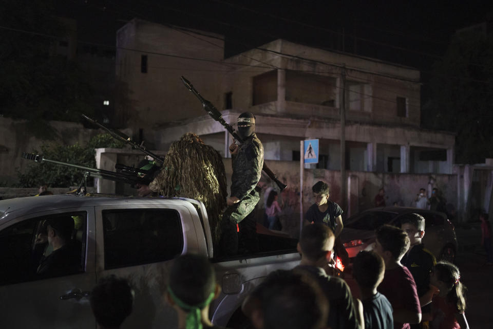 Hamas militants ride on a pickup truck during a rally in Gaza City, Wednesday, June 9, 2021. Hamas militants held a rally to commemorate the members of the group who were killed in an 11-day war with Israel in May. (AP Photo/Felipe Dana)