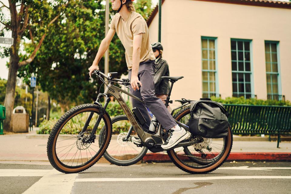 trek marlin+ alloy hardtail e-mountain bike shown with pannier bags and rack for commuting