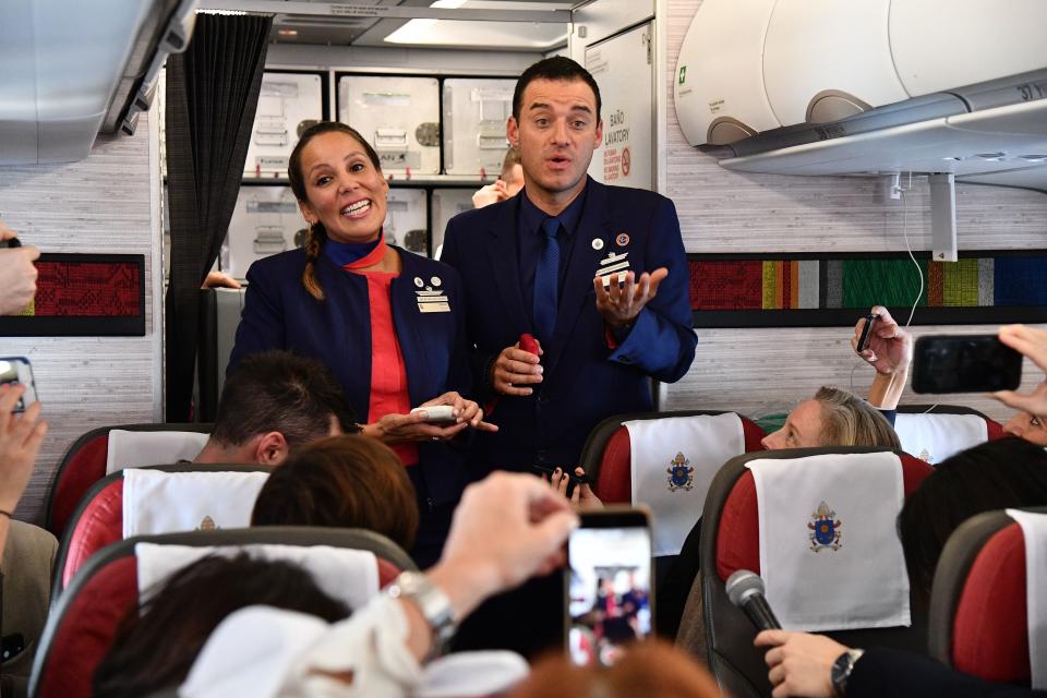 The newly married couple&nbsp;talk to&nbsp;reporters on the plane moments after being married by Pope Francis. (Photo: VINCENZO PINTO via Getty Images)