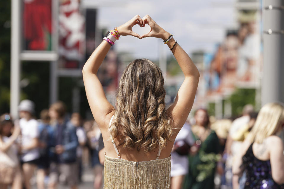 A fan poses for a photo outside Wembley Stadium ahead of Taylor Swift's first London concert, during her Eras Tour, in London, Friday June 21, 2024. (Lucy North/PA via AP)