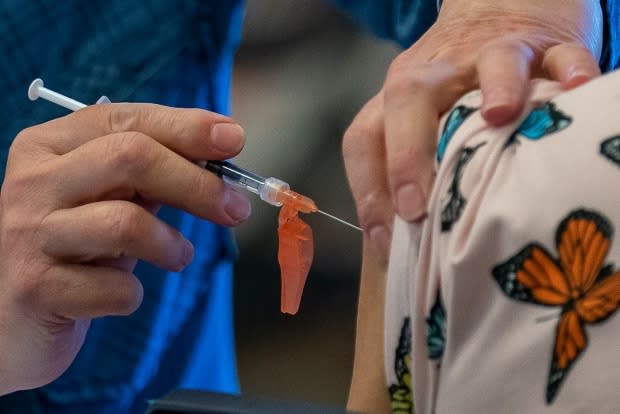 A person receives a COVID-19 vaccine at a clinic run by Vancouver Coastal Health in Richmond, B.C., on April 10.  (Jonathan Hayward/The Canadian Press - image credit)