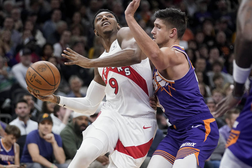 Toronto Raptors guard RJ Barrett (9) drives to the basket against Phoenix Suns guard Grayson Allen (8) during the first half of an NBA basketball game in Phoenix, Thursday, March. 7, 2024. (AP Photo/Darryl Webb)