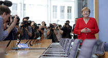 German Chancellor Angela Merkel, right, smiles as she arrives for her annual sommer press conference in Berlin, Germany, Friday, July 19, 2019. (AP Photo/Michael Sohn)