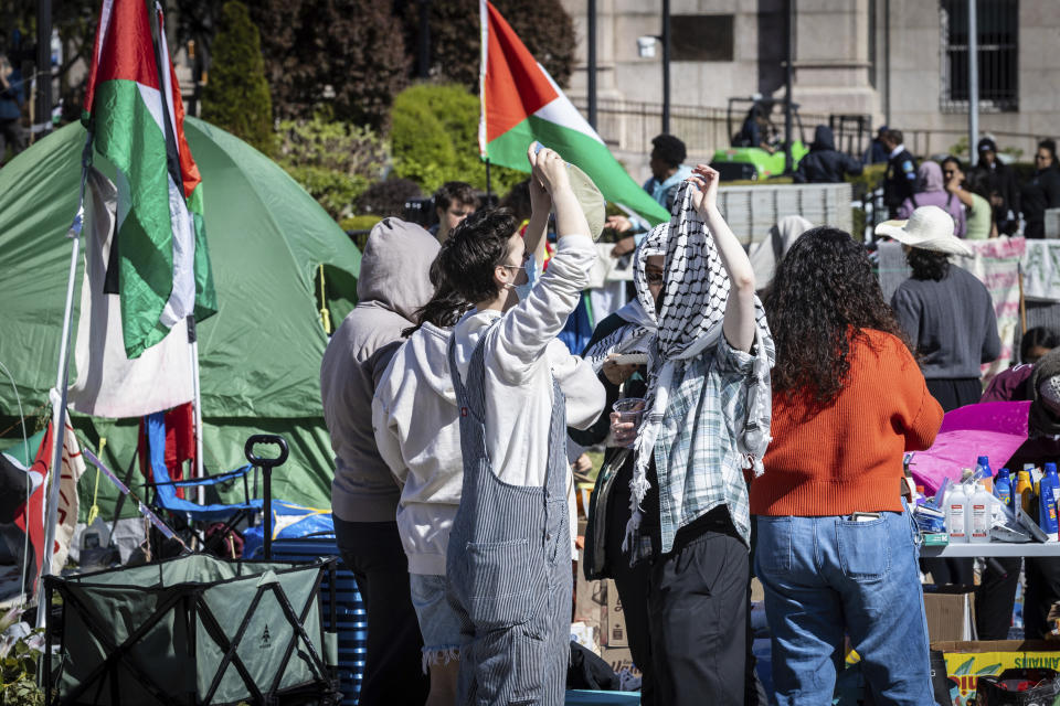 Dos estudiantes conversan en un campamento de protesta a favor de los palestinos, el lunes 22 de abril de 2024, en la Universidad de Columbia, en Nueva York. (AP Foto/Stefan Jeremiah)