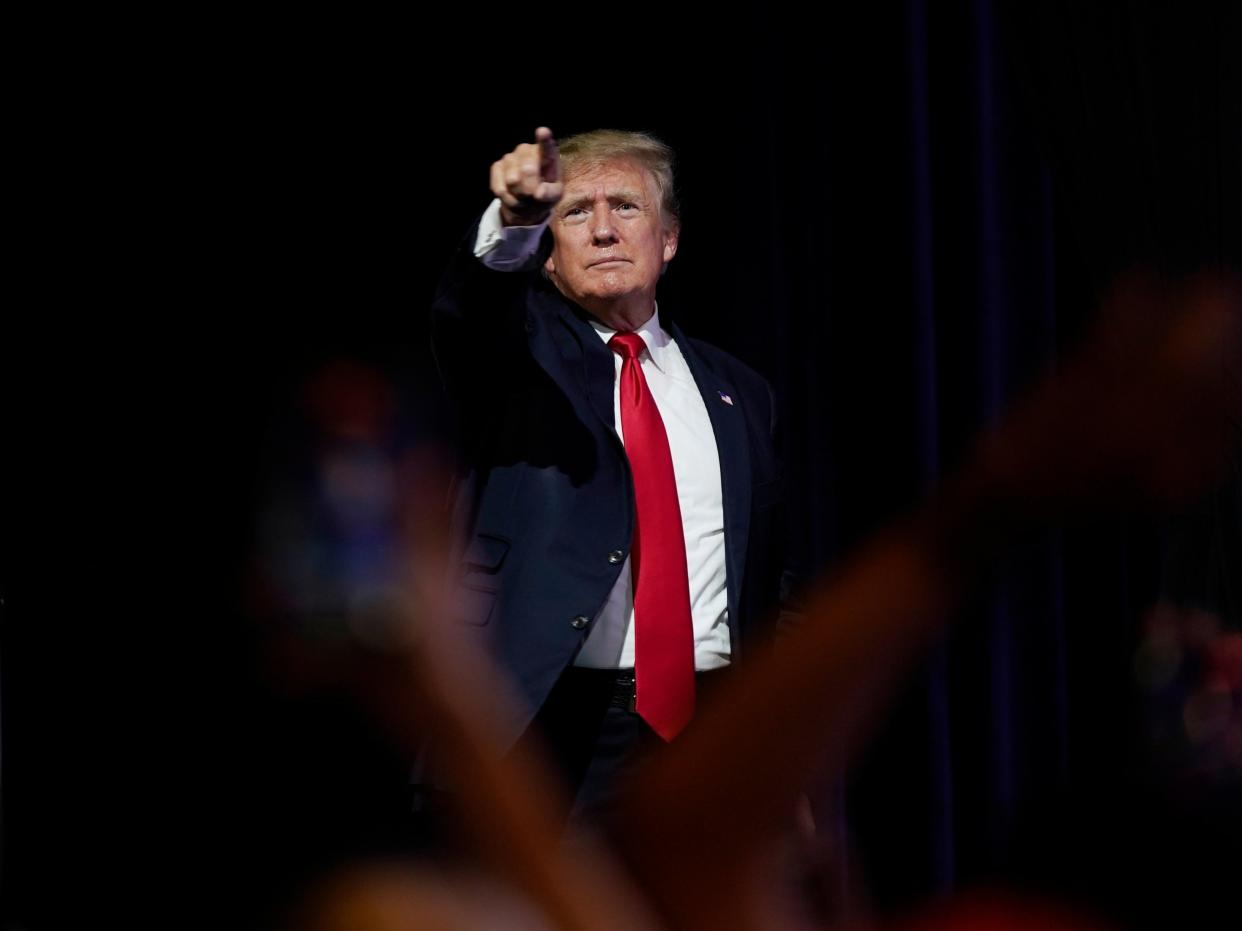 The former president points to supporters after speaking at a Turning Point Action gathering in Phoenix (AP)