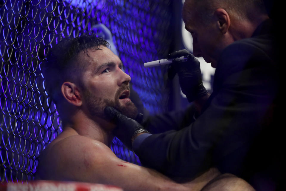 Chris Weidman, left, is examined by a doctor after he lost to Ronaldo Souza during the third round of a middleweight mixed martial arts bout at UFC 230, Sunday, Nov. 4, 2018, at Madison Square Garden in New York. (AP Photo/Julio Cortez)