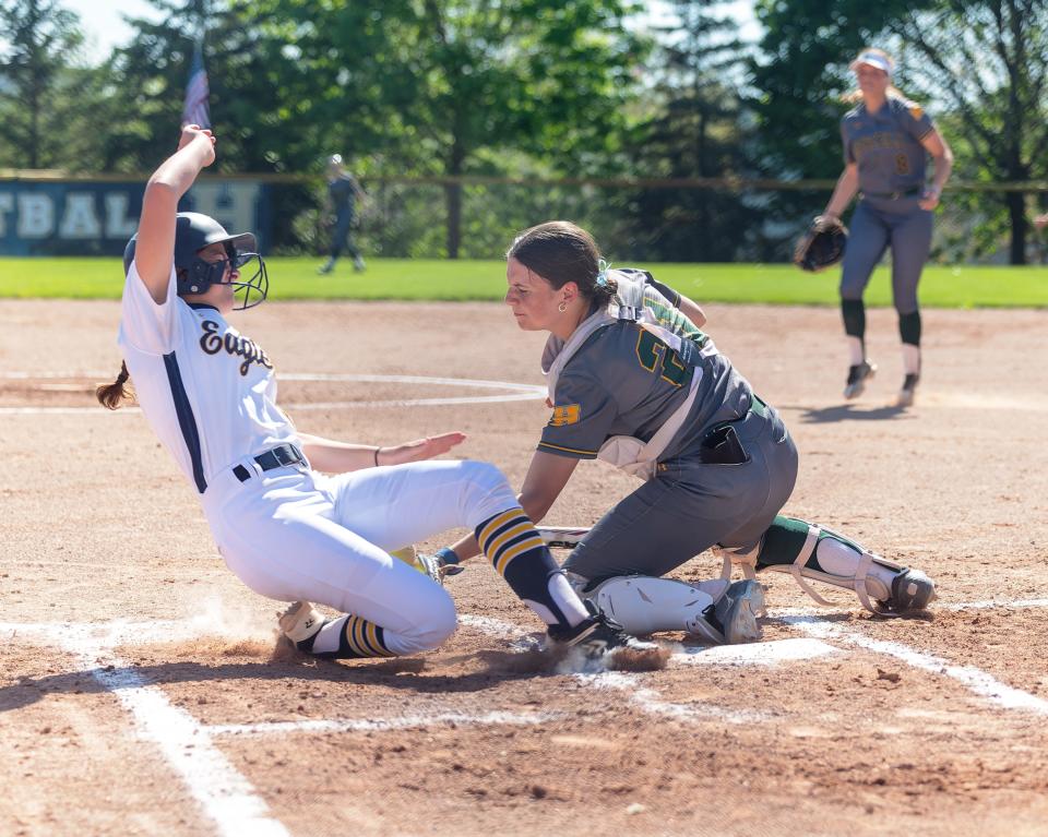 Hartland's Jamie Smokovitz slides in to score as Howell's Easton Lavery attempts the tag Wednesday, May 8, 2024.