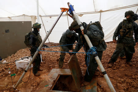 FILE PHOTO: Israeli soldiers lift the cover of an Israeli-dug hole into a cross-border tunnel dug from Lebanon into Israel, as seen on the Israeli side of the border, near the town of Metula December 19, 2018 REUTERS/ Ronen Zvulun/File Photo