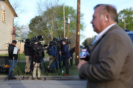 Members of the media stage nearby as law enforcement personnel investigate a home linked to the bomber in Pflugerville, Texas, U.S., March 21, 2018. REUTERS/Loren Elliott