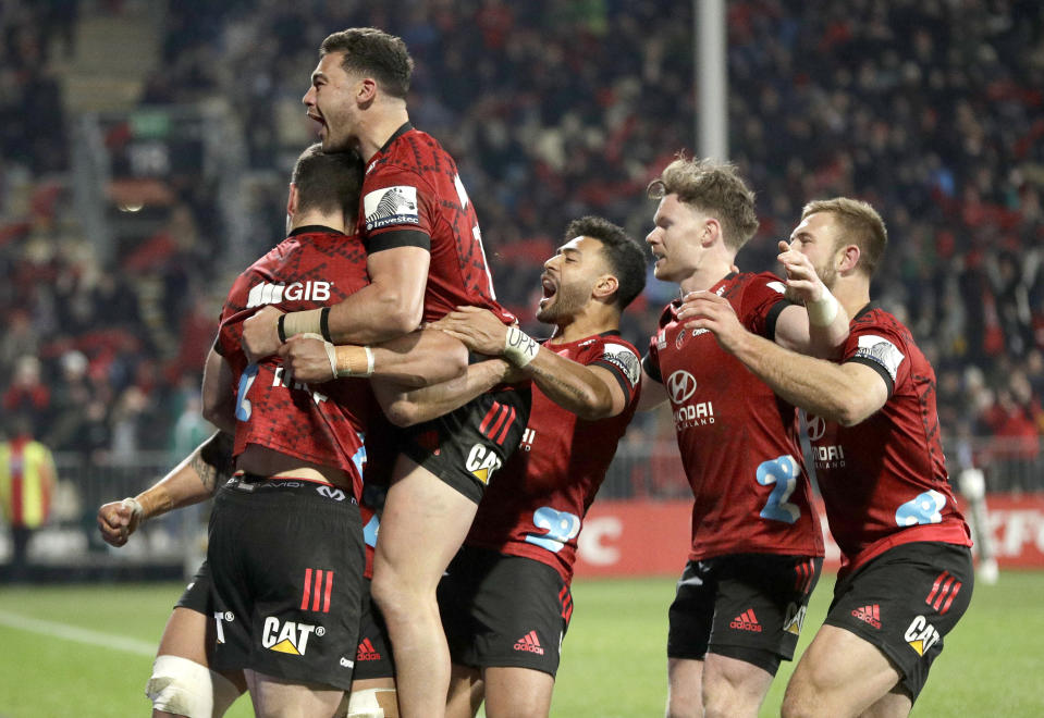 Crusaders Will Jordan, left, is congratulated by teammates after scoring his team's match winning try during the Super Rugby Aotearoa rugby game between the Crusaders and the Blues in Christchurch, New Zealand, Saturday, July 11, 2020. (AP Photo/Mark Baker)