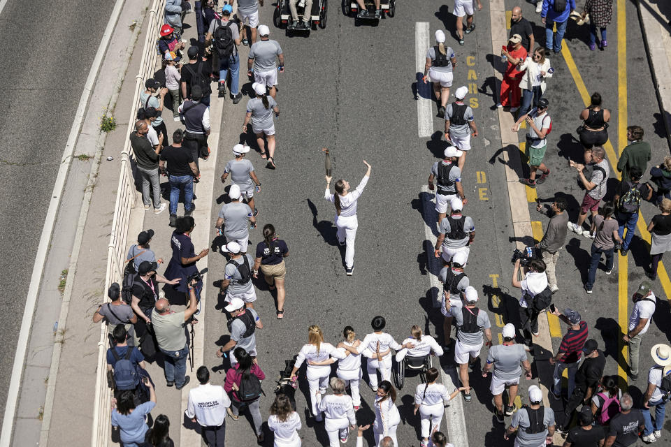 Mariia Vysochanska of Ukraine, accompanied by 27 EU athletes and paraathletes, participates in the Olympic torch relay in Marseille, southern France, Thursday, May 9, 2024. Torchbearers are to carry the Olympic flame through the streets of France' s southern port city of Marseille, one day after it arrived on a majestic three-mast ship for the welcoming ceremony. (AP Photo/Laurent Cipriani)