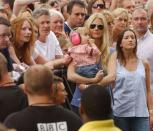 <p>While her father Chris Martin and his Coldplay bandmates performed at London's Live 8 concert, a one-year-old Apple dons hearing protective earphones — while sucking her thumb — in the VIP section. </p>