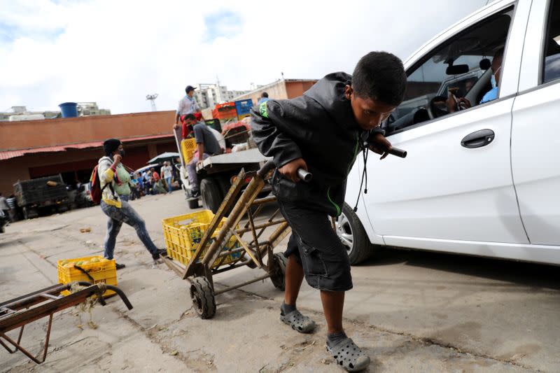 A child pulls a cart at the Coche wholesale market amid coronavirus (COVID-19) disease outbreak in Caracas