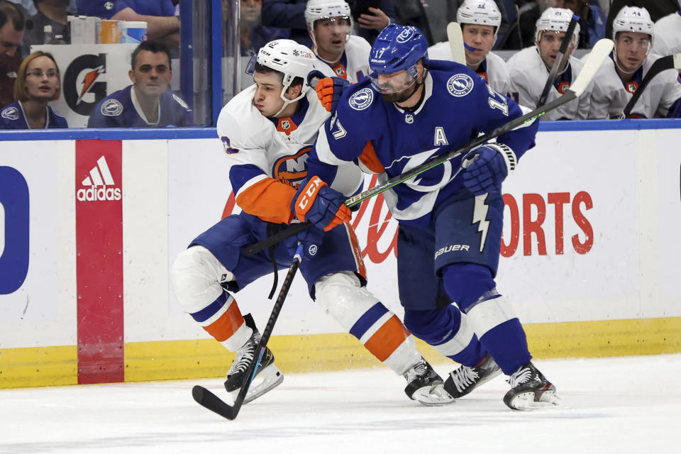 Tampa Bay Lightning's Alex Killorn (17) checks New York Islanders' Mathew Barzal during the first period of an NHL hockey game Monday, Nov. 15, 2021, in Tampa, Fla. (AP Photo/Mike Carlson)