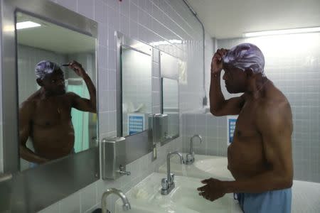 Inmate Derrick Brooks, 65, who has cancer, looks in the mirror as he shaves in the hospice at the California Medical Facility prison in Vacaville, California, U.S., May 23, 2018. REUTERS/Lucy Nicholson