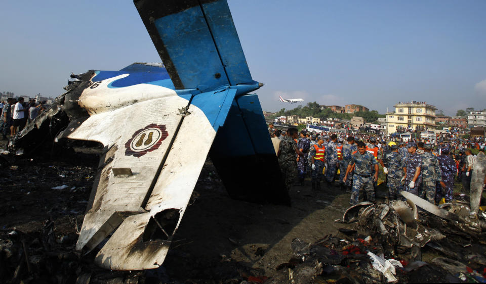 Nepalese police search through the debris at the crash site of a Sita Air airplane near Katmandu, Nepal, early Friday, Sept. 28, 2012. The plane carrying trekkers into the Everest region crashed just after takeoff Friday morning in Nepal's capital, killing all 19 people on board, authorities said. (AP Photo/Niranjan Shrestha)