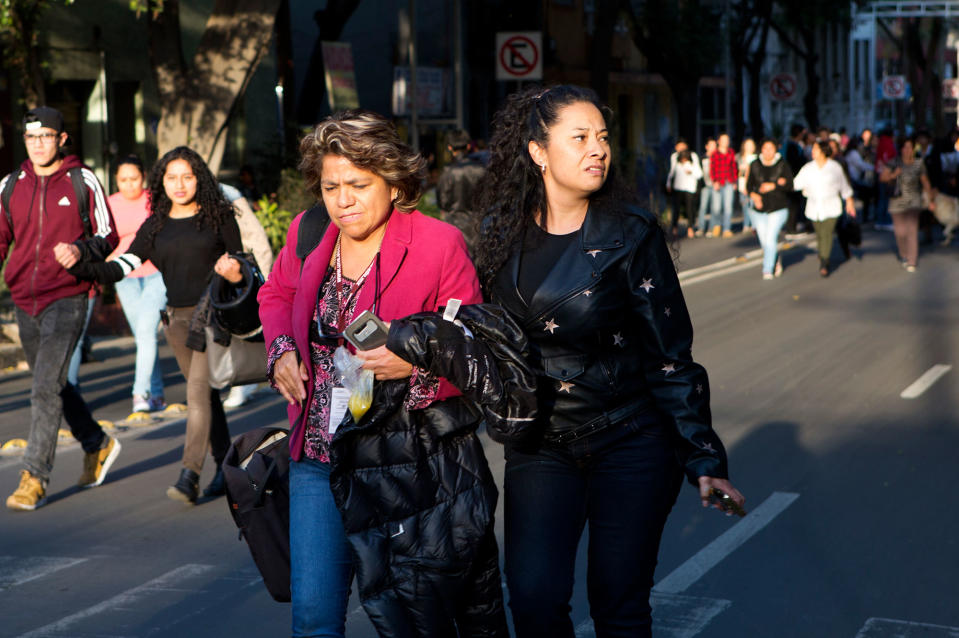 <p>People walk down the center of a street in the Roma neighborhood after an earthquake shook Mexico City, Friday, Feb. 16, 2018. (Photo: Rebecca Blackwell/AP) </p>