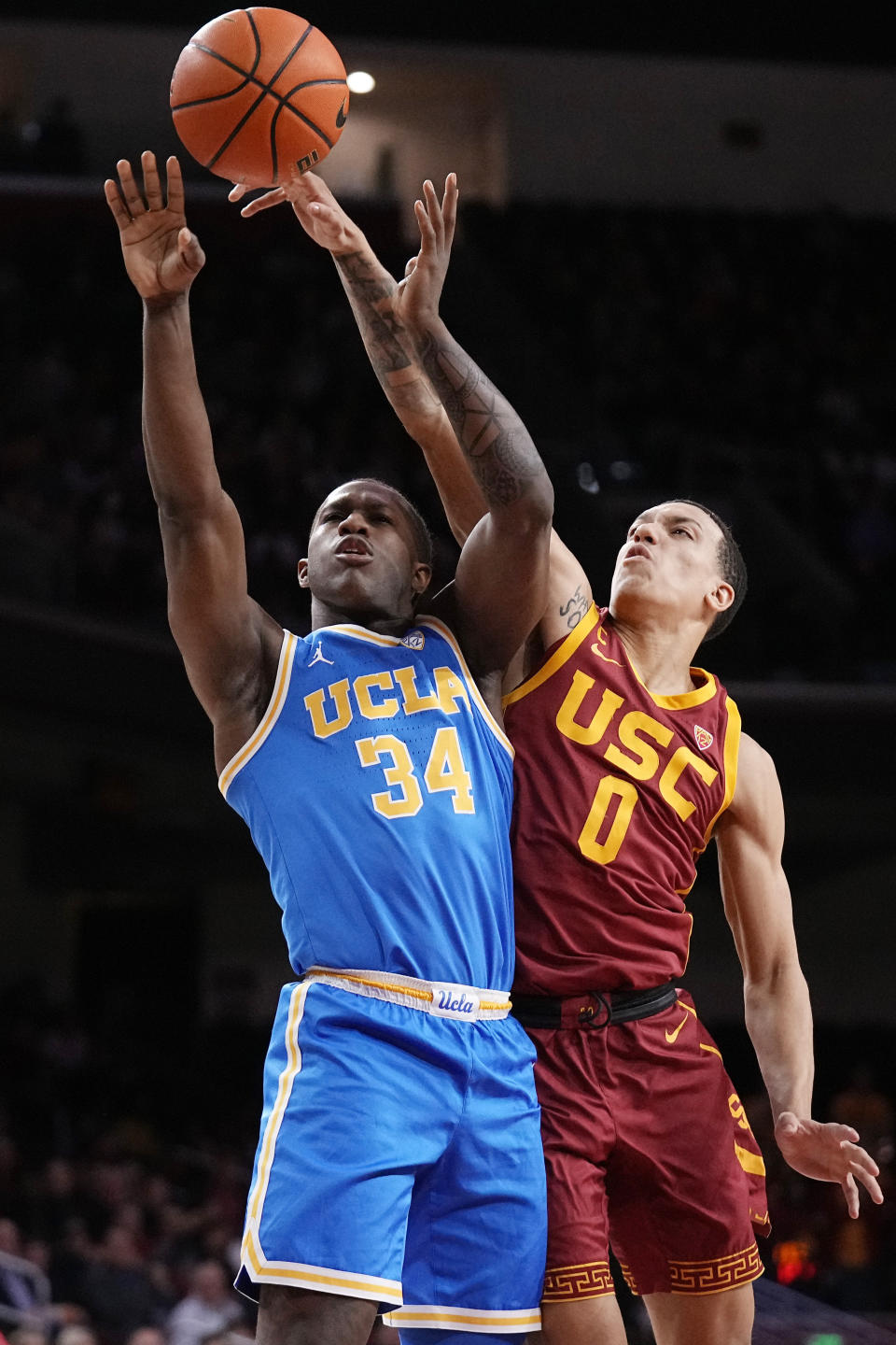 UCLA guard David Singleton (34) shoots as Southern California forward Kobe Johnson (0) defends during the first half of an NCAA college basketball game Thursday, Jan. 26, 2023, in Los Angeles. (AP Photo/Mark J. Terrill)