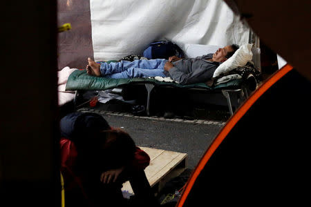 People sleep in a tent, along the street, as they wait for news of their loved ones, next to a collapsed building, after an earthquake in Mexico City, Mexico September 25, 2017. REUTERS/Henry Romero