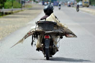 <p>A fishmonger carries a shark on his motorcycle in Padang, West Sumatra, Indonesia Aug. 25, 2016. (Photo: Antara Foto/Iggoy el Fitra/Reuters)</p>