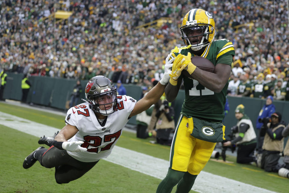 Green Bay Packers wide receiver Jayden Reed (11) catches a 17-yard touchdown pass in front of Tampa Bay Buccaneers cornerback Zyon McCollum (27) during the second half of an NFL football game, Sunday, Dec. 17, 2023, in Green Bay, Wis. (AP Photo/Matt Ludtke)