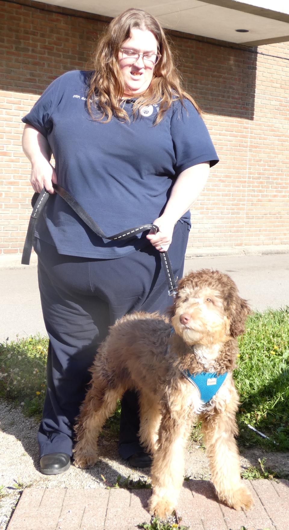 Dispatcher Cindy Barth holds the leash of Charlie, the Bucyrus Police Department's new  therapy dog.