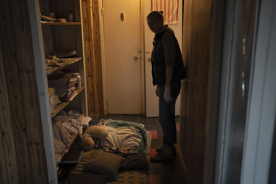 A woman shows a spot where she sleeps in her apartment corridor during Russian rocket attacks, in Kyiv, Ukraine, Thursday, Sept. 21, 2023. (AP Photo/Roman Hrytsyna)