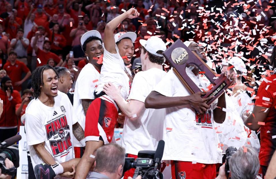 N.C. State’s KJ Keatts, center, and team celebrate after placing their name on the Final Four poster after N.C. State’s 76-64 victory over Duke in their NCAA Tournament Elite Eight matchup at the American Airlines Center in Dallas, Texas, Sunday, March 31, 2024.