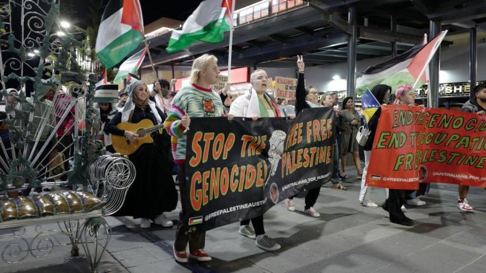 Protesters hold banners and flags