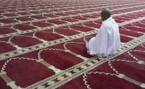 A Muslim man attends his first prayers for his Umrah pilgrimage, at Taneem Mosque in the Al-Hil area of the holy city of Mecca January 13, 2014. Muslims mark Eid Mawlid al-Nabawi, or the birth of Prophet Mohammad on Tuesday. REUTERS/Amr Abdallah Dalsh (SAUDI ARABIA - Tags: RELIGION ANNIVERSARY)