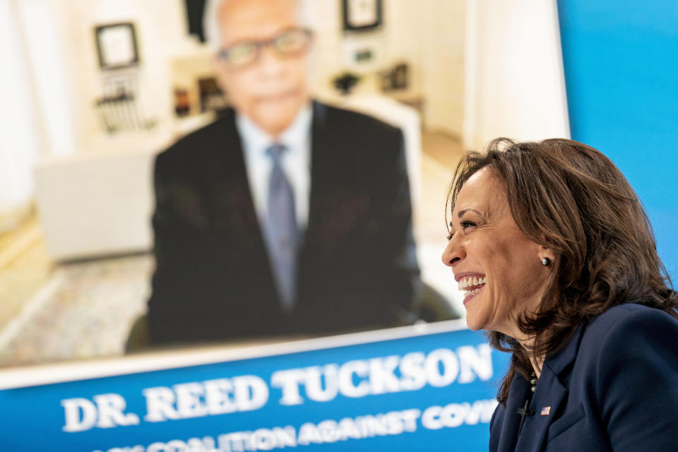 Dr. Reed Tuckson with the Black Coalition Against COVID, is displayed on a monitor behind Vice President Kamala Harris as she speaks during a virtual meeting with community leaders to discuss COVID-19 public education efforts in the South Court Auditorium in the Eisenhower Executive Office Building on the White House Campus, Thursday, April 1, 2021, in Washington. (AP Photo/Andrew Harnik)