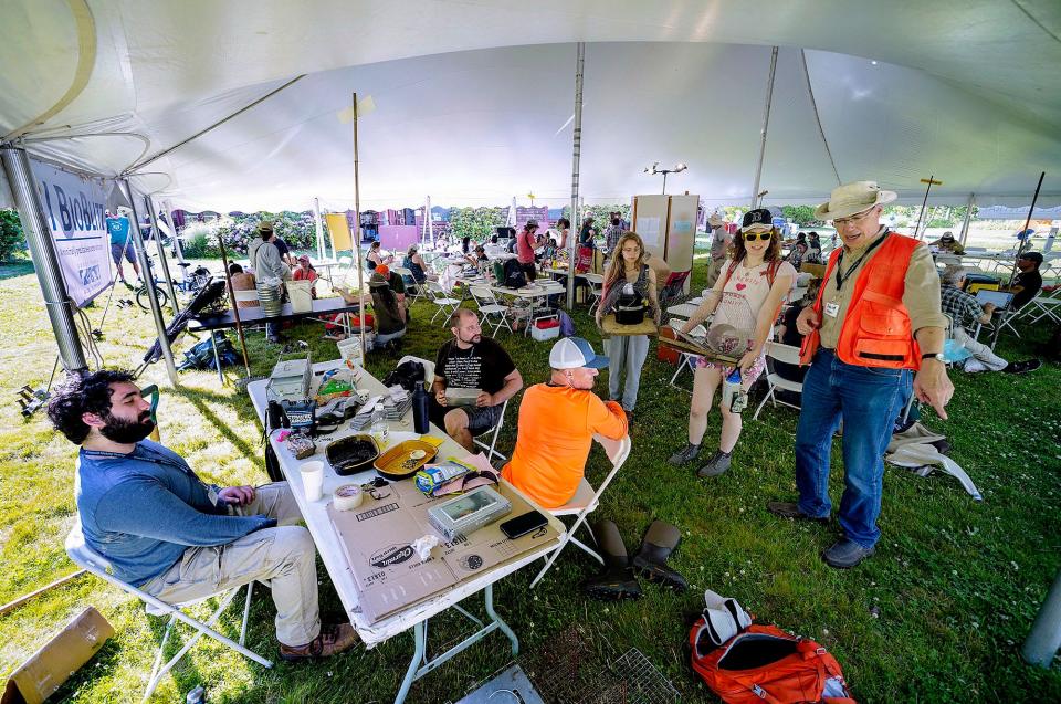 David Gregg, right, executive director of the Rhode Island Natural History Survey, works with BioBlitzers under a tent.