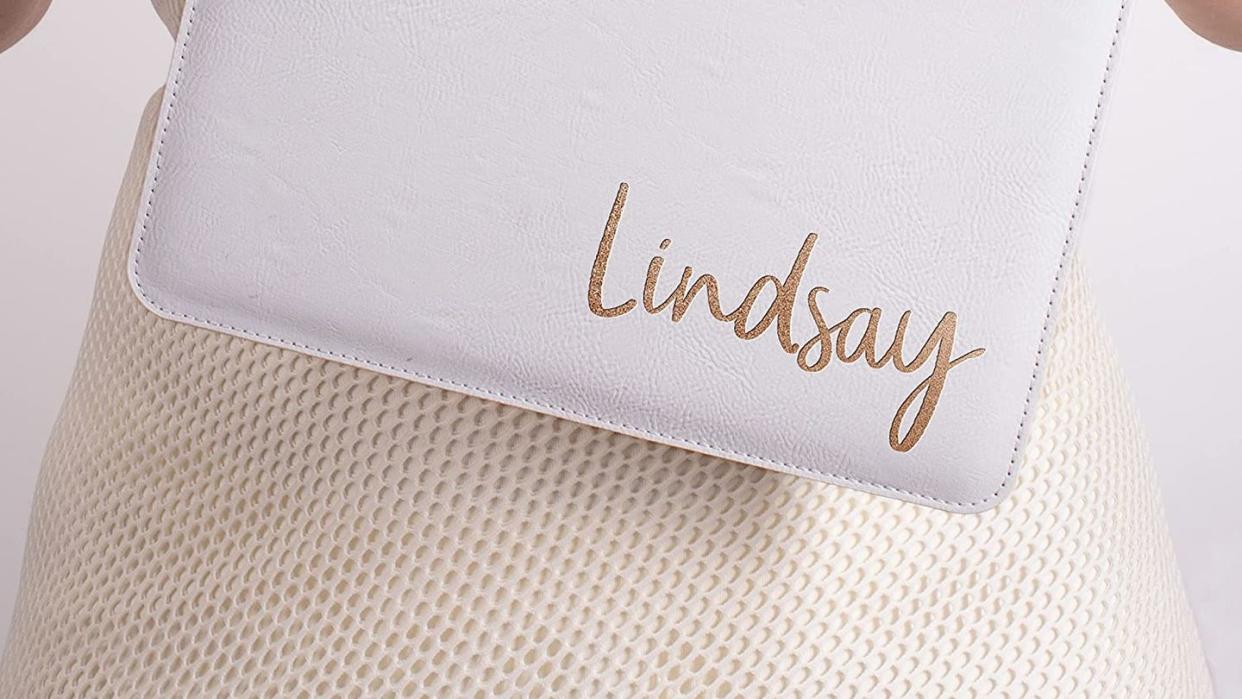 white clutch wristlet that says lindsay in gold at bottom right