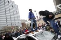 Protesters jump on a police car at a rally to protest the death of Freddie Gray who died following an arrest in Baltimore, Maryland April 25, 2015. REUTERS/Shannon Stapleton