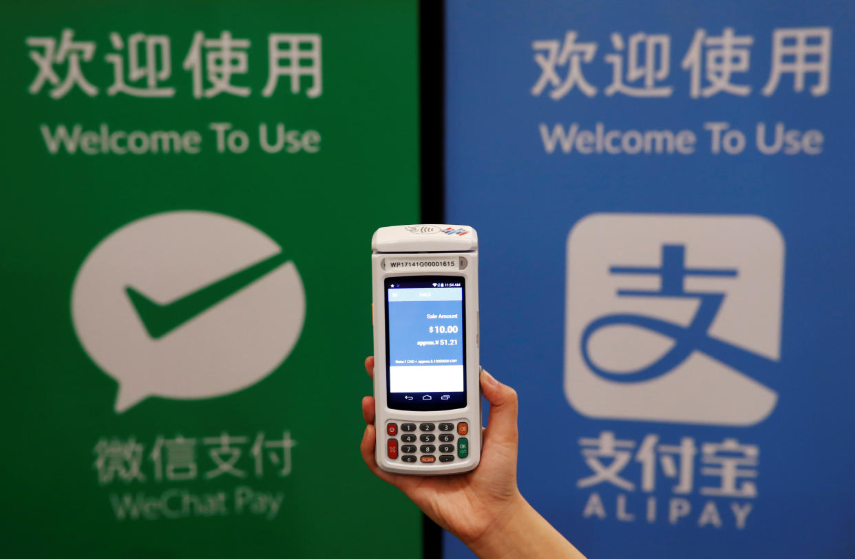 A woman demonstrates a high security digital unit built by Motion Pay, that allows customers to pay in Chinese yuan renminbi using Chinese online money payment services “WeChat Pay”, and “Alipay”, where payments get converted to Canadian dollars at point of sales locations in Canadian stores and businesses, in Toronto, Canada, May 24, 2017. REUTERS/Mark Blinch