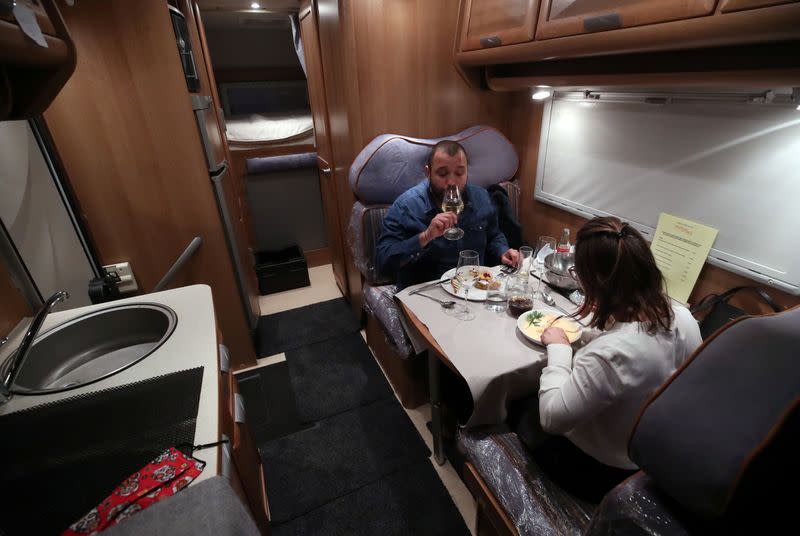 Customers enjoy dinner sitting inside a motorhome camper parked at the Belgian restaurant Matthias And Sea, despite the COVID-19 pandemic lockdown in Tarcienne