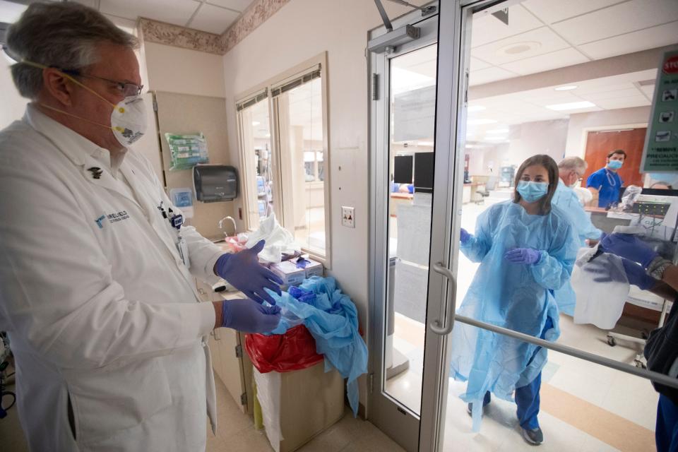 Dr. Stephen Threlkeld, infectious disease specialist at Baptist Memphis’ infection prevention program, prepares to remove his protective gear after checking on a patient with COVID-19 at the hospital on Thursday, May 14, 2020.