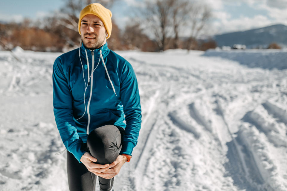 Man stretching for better results on running track