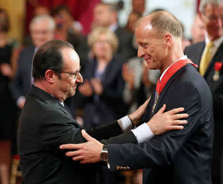 FILE PHOTO: French President Francois Hollande, left, awards German businessman Thomas Enders, chief executive of Airbus Group, with the medal of Commander of the Legion of Honor, during a ceremony at the Elysee Palace in Paris, Tuesday April 14, 2015. REUTERS/Remy de la Mauviniere/Pool/File Photo