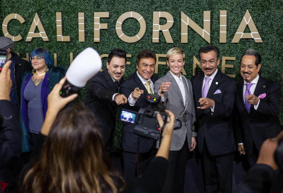 Worldwide Latin music stars Los Tigres del Norte flank fellow California Hall of Fame inductee and soccer star Megan Rapinoe on the red carpet Tuesday, Dec. 13, 2022, before their induction ceremony at the California Museum in downtown Sacramento.