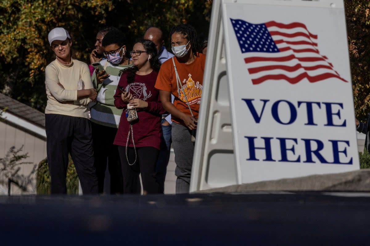 People wait in line to cast their ballots during early voting for the midterm elections at the South Cobb Regional Library, in Mableton Georgia, on 4 November 2022 (REUTERS)