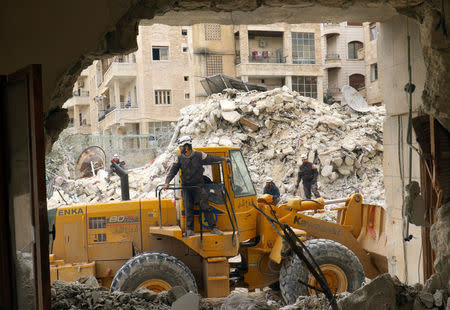 Civil Defence members and civilians remove rubble in a damaged site after an airstrike on Idlib city, Syria March 15, 2017. REUTERS/Ammar Abdullah