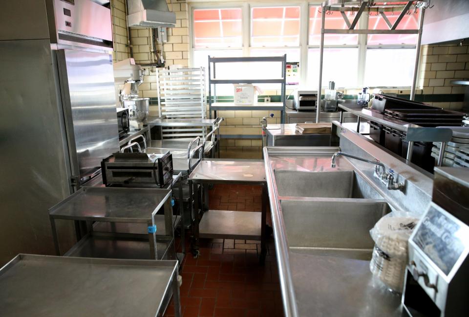 County Commissioner Derek Dieter shows some of the kitchen items that are now up for bid in the first auction of goods at Portage Manor in South Bend on Wednesday.