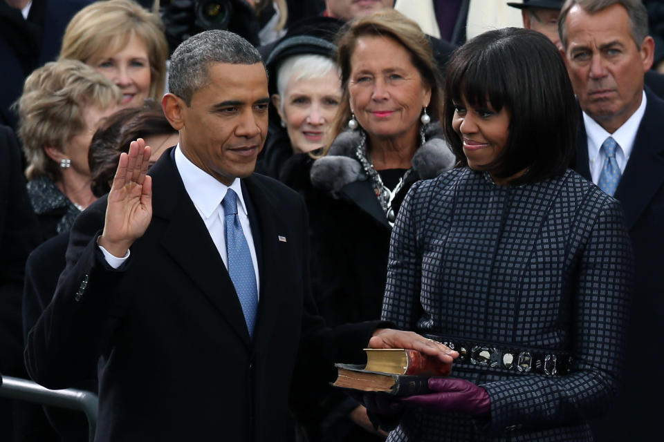 U.S. President Barack Obama is sworn in during the public ceremony as First lady Michelle Obama looks on during the presidential inauguration on the West Front of the U.S. Capitol January 21, 2013 in Washington, DC. Barack Obama was re-elected for a second term as President of the United States. (Photo by Alex Wong/Getty Images)