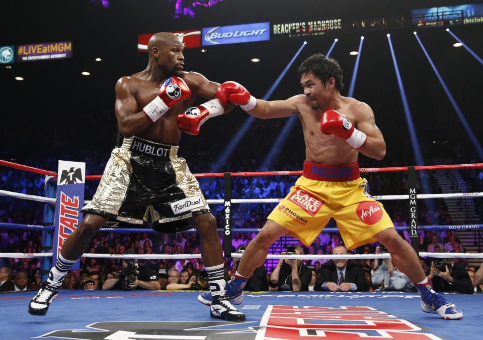 Manny Pacquiao, right, from the Philippines, trades blows with Floyd Mayweather Jr., during their welterweight title fight on Saturday, May 2, 2015 in Las Vegas.  (AP Photo/John Locher)